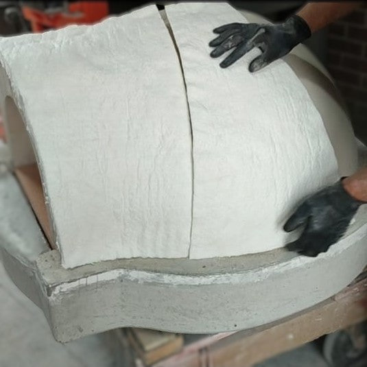 Ceramic fibre blanket insulation being installed over the refractory pizza oven dome.