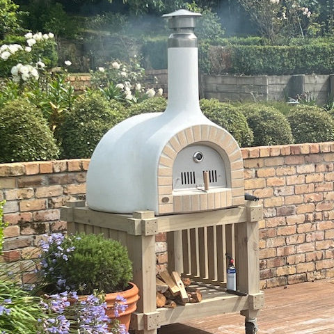 Customer-built Kiwi Pizza Oven kitset with a white rendered finish in a New Zealand garden.