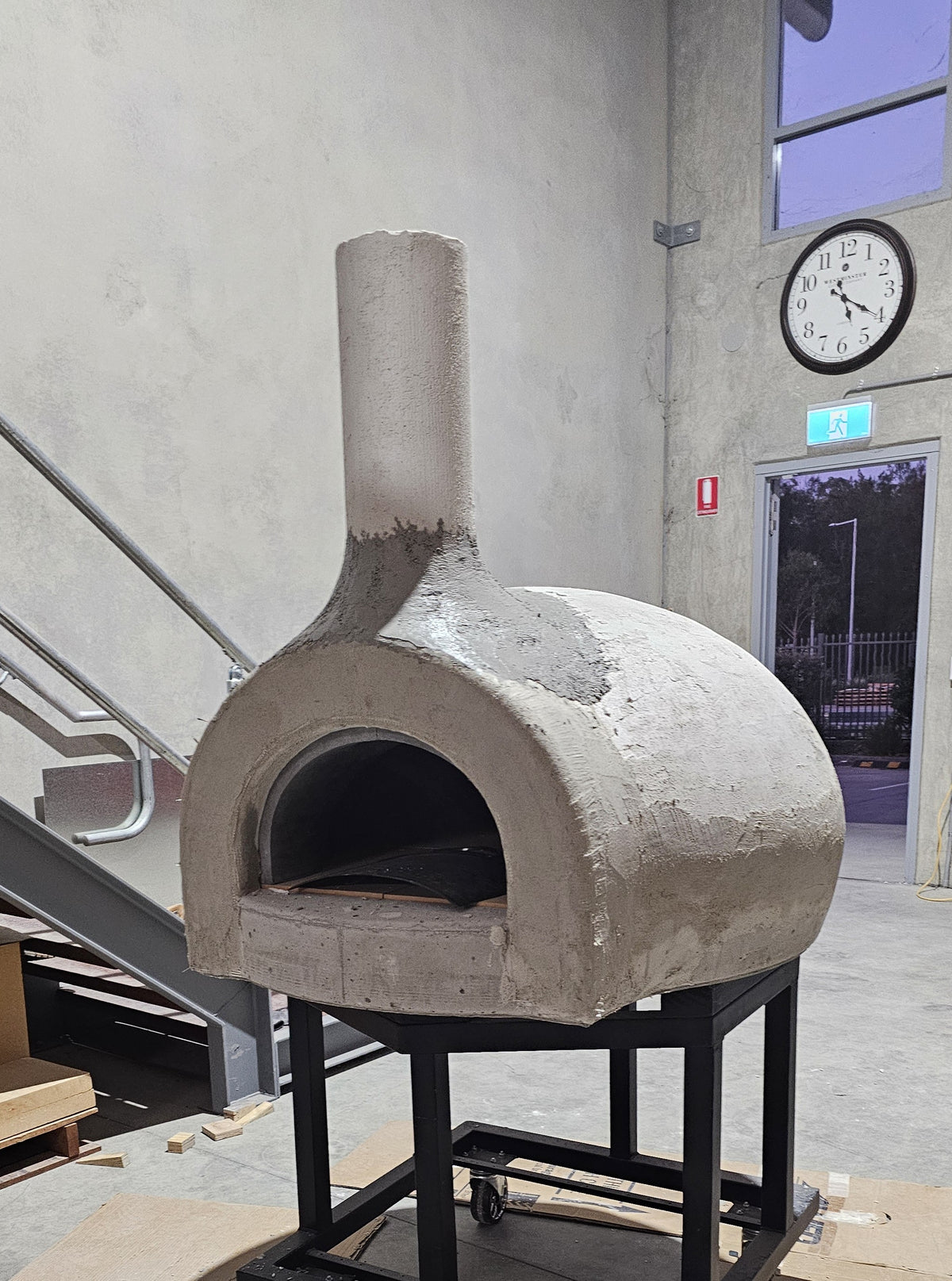 Precast entrance and chimney section during wood-fired pizza oven kit assembly.