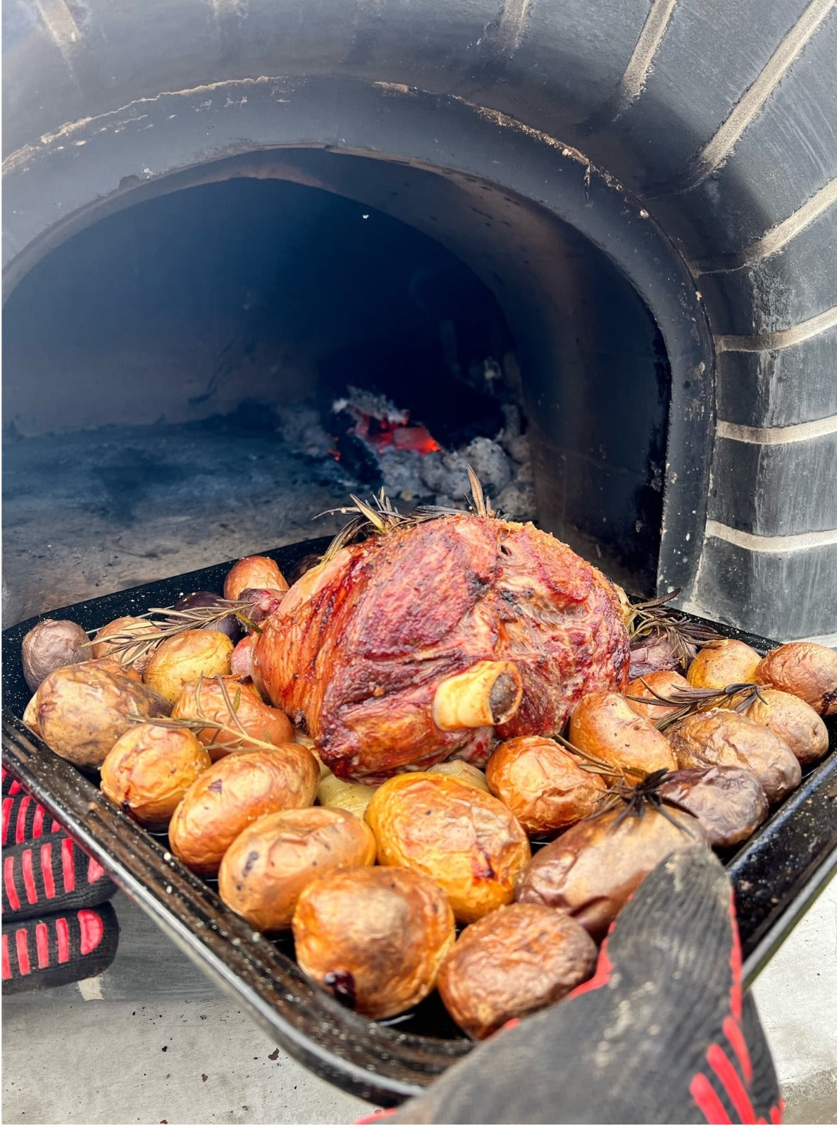 Roast lamb and potatoes cooked in a wood-fired pizza oven