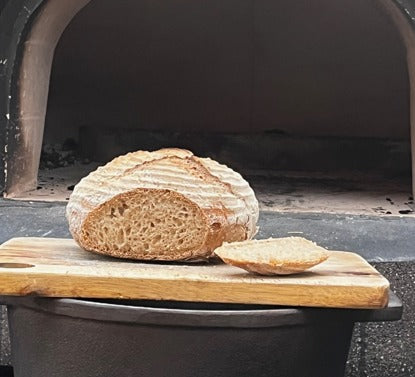 Sourdough bread baked with retained heat in a wood-fired pizza oven